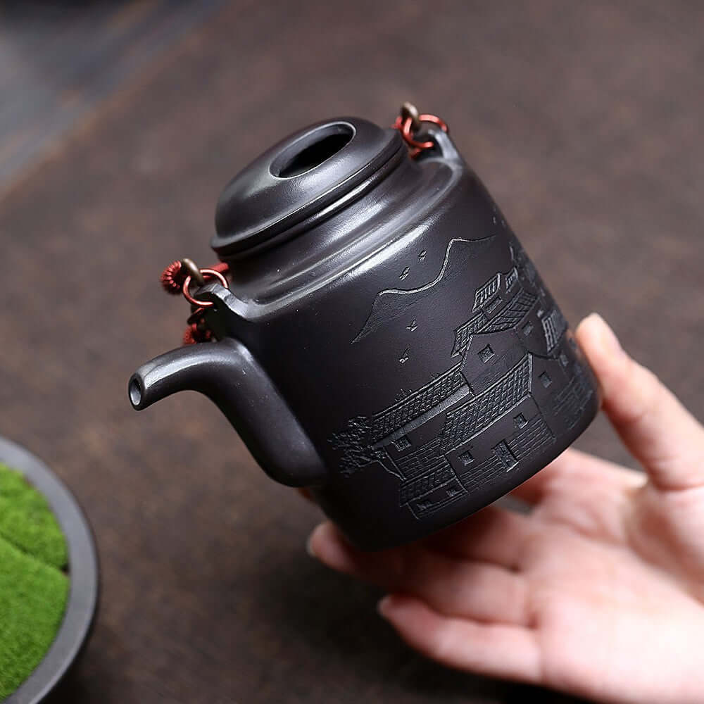 Handmade Yixing purple sand teapot showcasing intricate village design, perfect for kung fu tea serving.