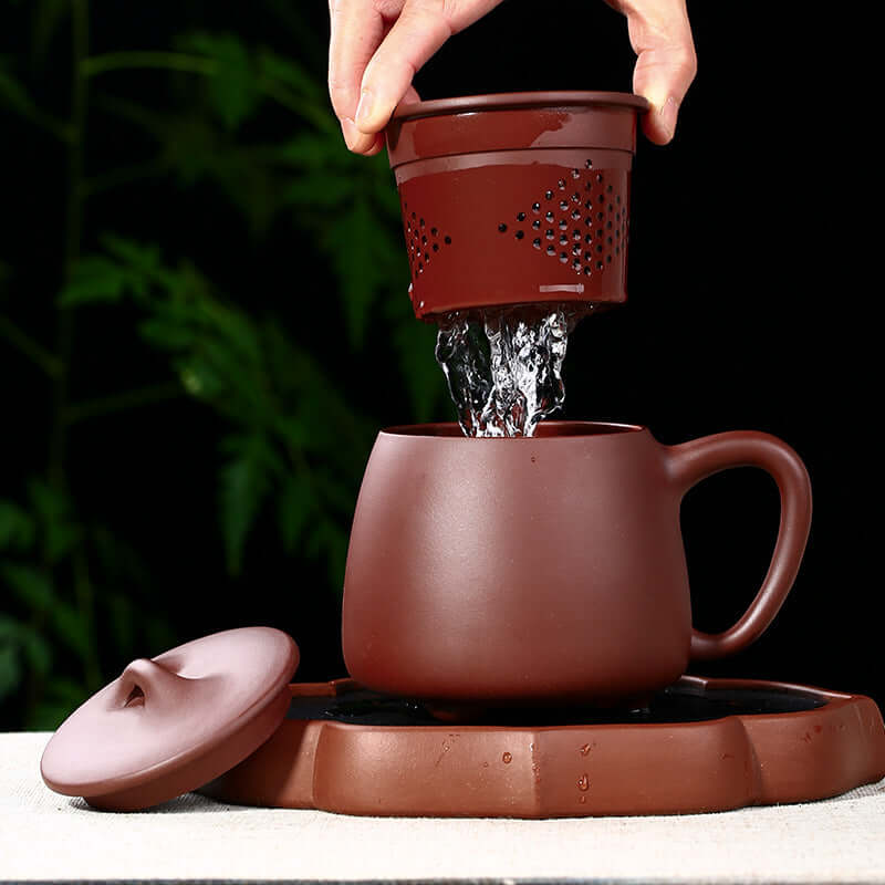 Handmade Yixing purple sand tea cup with strainer pouring water, perfect for tea ceremonies and business gifts.