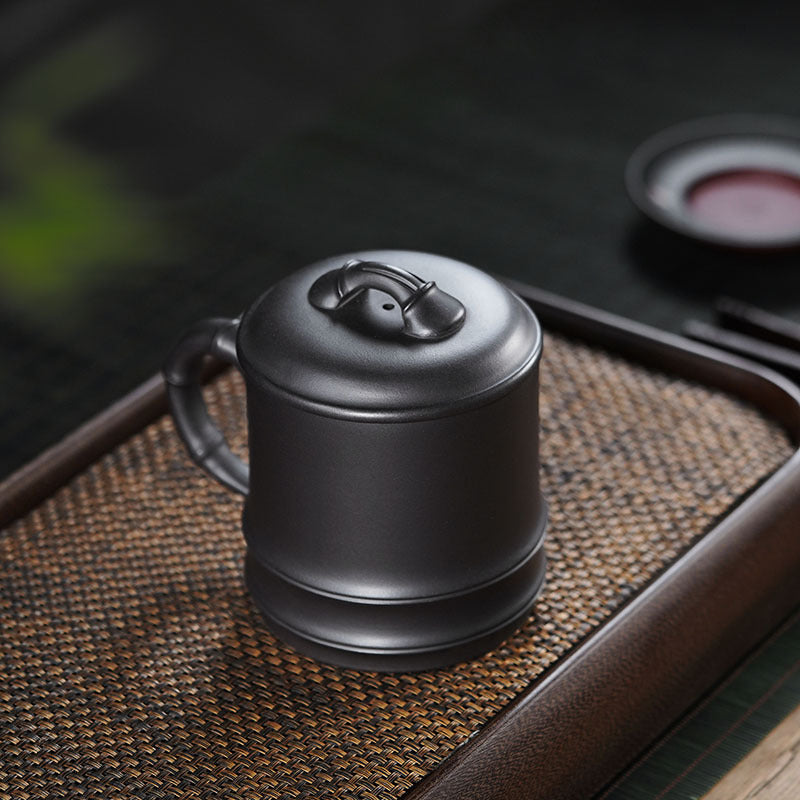 Handmade Yixing original purple sand lidded cup on a tea tray, showcasing a unique double-walled design for tea brewing.
