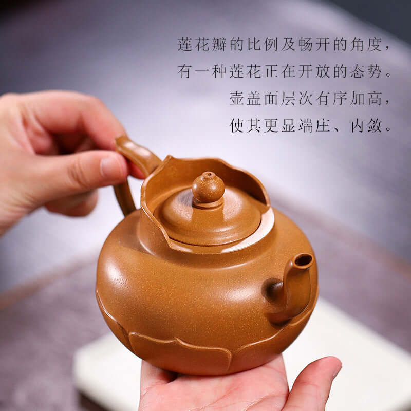 Handmade Yixing purple sand teapot featuring elegant lotus design, held in hand, showcasing craftsmanship and unique shape.