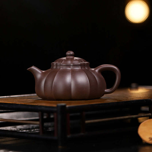 Handmade Yixing purple sand teapot with a unique pumpkin shape, crafted by skilled artisans for tea brewing.