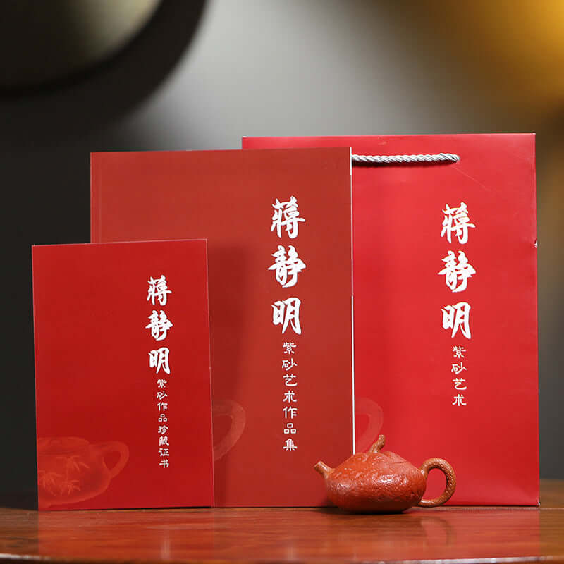 Handmade Yixing purple sand teapot in red gift packaging with accompanying certificates and booklets.
