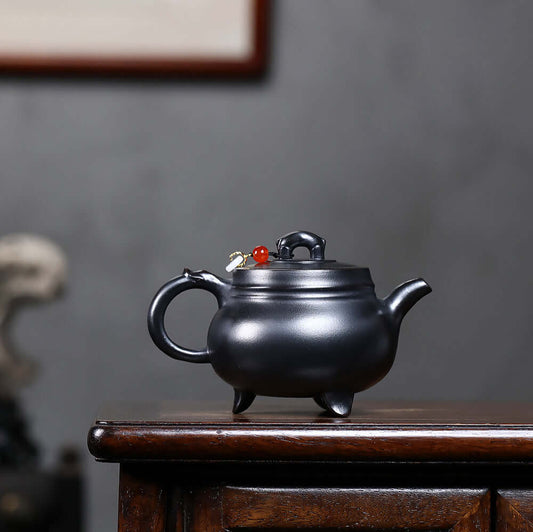 Handmade Yixing purple sand teapot with three legs, showcasing the artisan craftsmanship for Kung Fu tea sets.