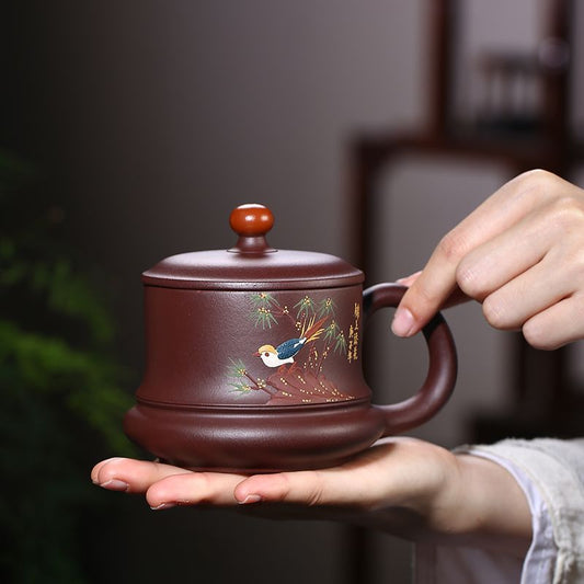Handmade Yixing purple sand tea cup featuring intricate bird painting, crafted with unique design and comfortable grip.