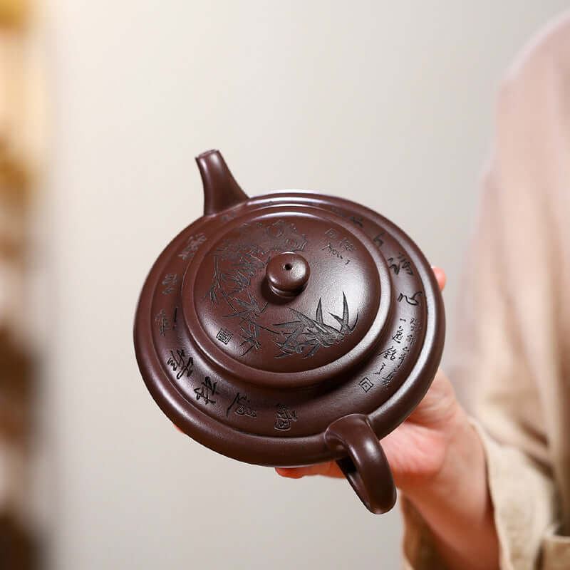 Handmade Yixing purple sand teapot with intricate engravings, showcasing fine craftsmanship and unique design.