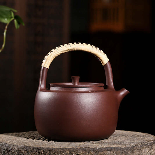 Handmade Yixing purple sand teapot with rattan handle, perfect for brewing tea and resistant to high temperatures.