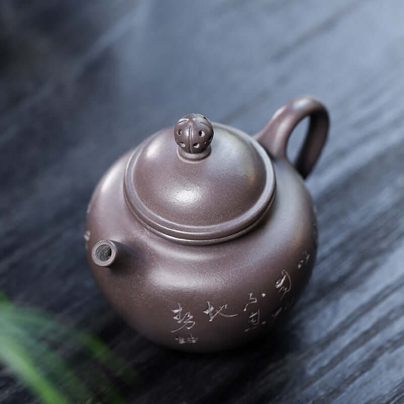 Handmade Yixing purple sand teapot with intricate carvings and unique lid design.