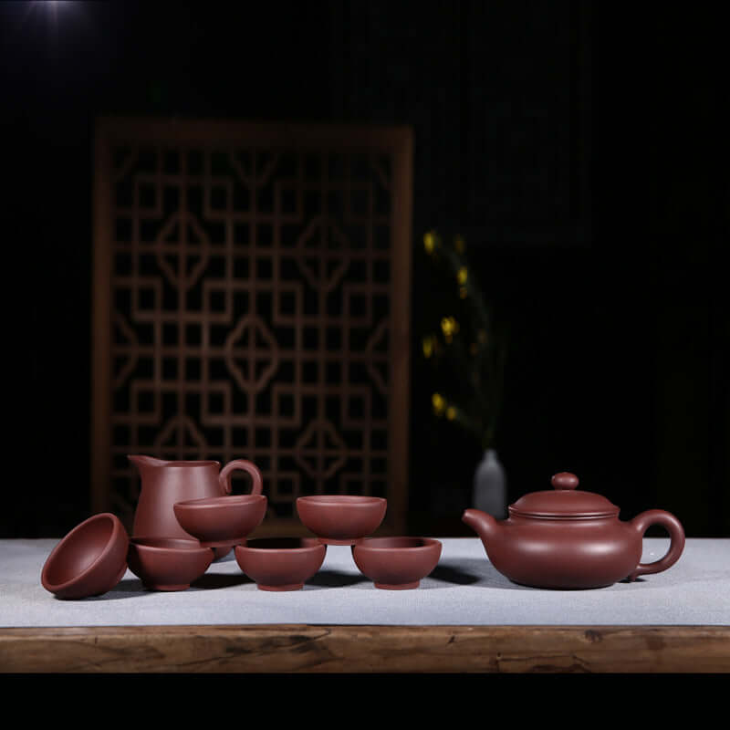Handmade Yixing purple sand teapot set with six cups and pitcher, perfect for tea enthusiasts and gift options.
