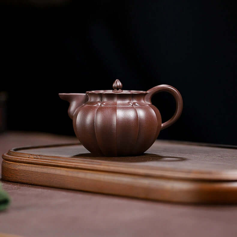 Handmade Yixing purple sand teapot with unique ribbed design, perfect for home tea brewing.