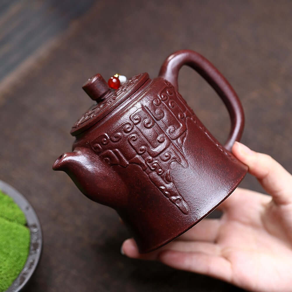 Handmade Yixing purple sand teapot featuring ancient red mud with intricate designs, perfect for kung fu tea sets.