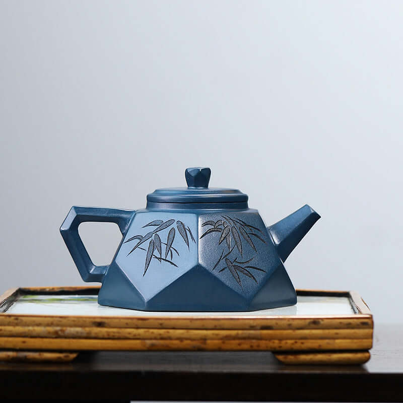 Handmade Yixing purple sand teapot in a blue color with bamboo design, showcasing traditional craftsmanship.