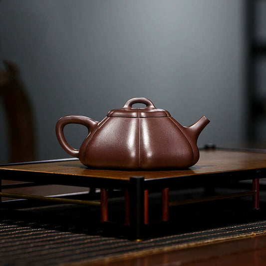 Handmade Yixing purple sand teapot on a wooden display, showcasing intricate craftsmanship and original purple sand material.