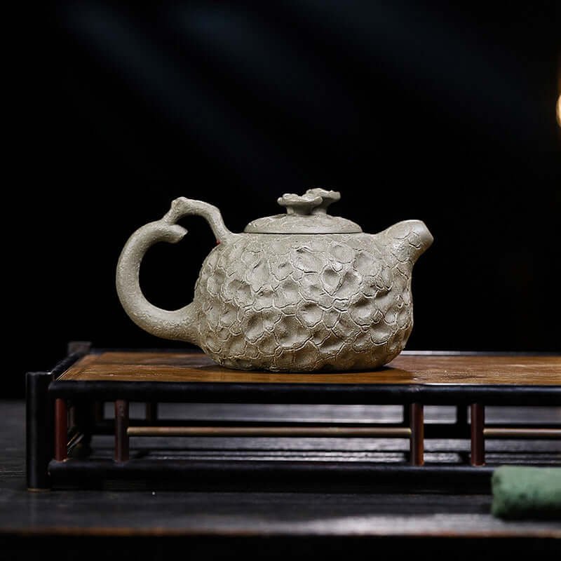 Handmade Yixing purple sand teapot with floral design, crafted from original purple sand, perfect for tea ceremonies.
