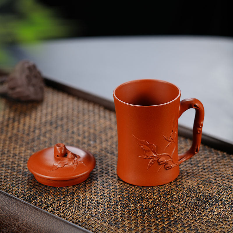 Handmade Yixing purple sand teapot with cover, featuring intricate floral design, perfect for tea enthusiasts.