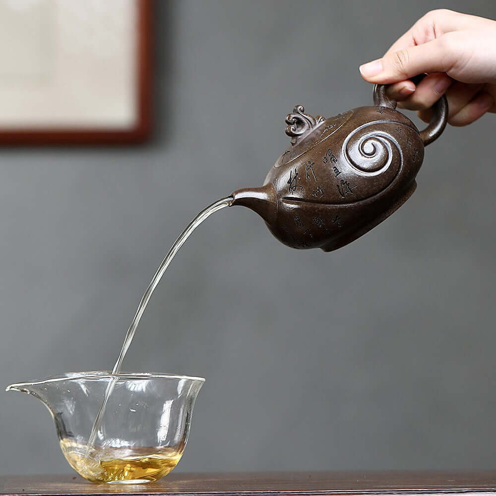 Handmade Yixing purple sand teapot pouring tea, original craftsmanship, perfect for kung fu tea ceremonies.