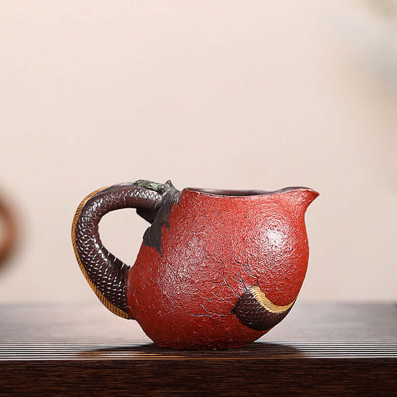 Handmade Yixing purple sand fair cup with dragon-shaped handle, showcasing traditional craftsmanship and unique design.