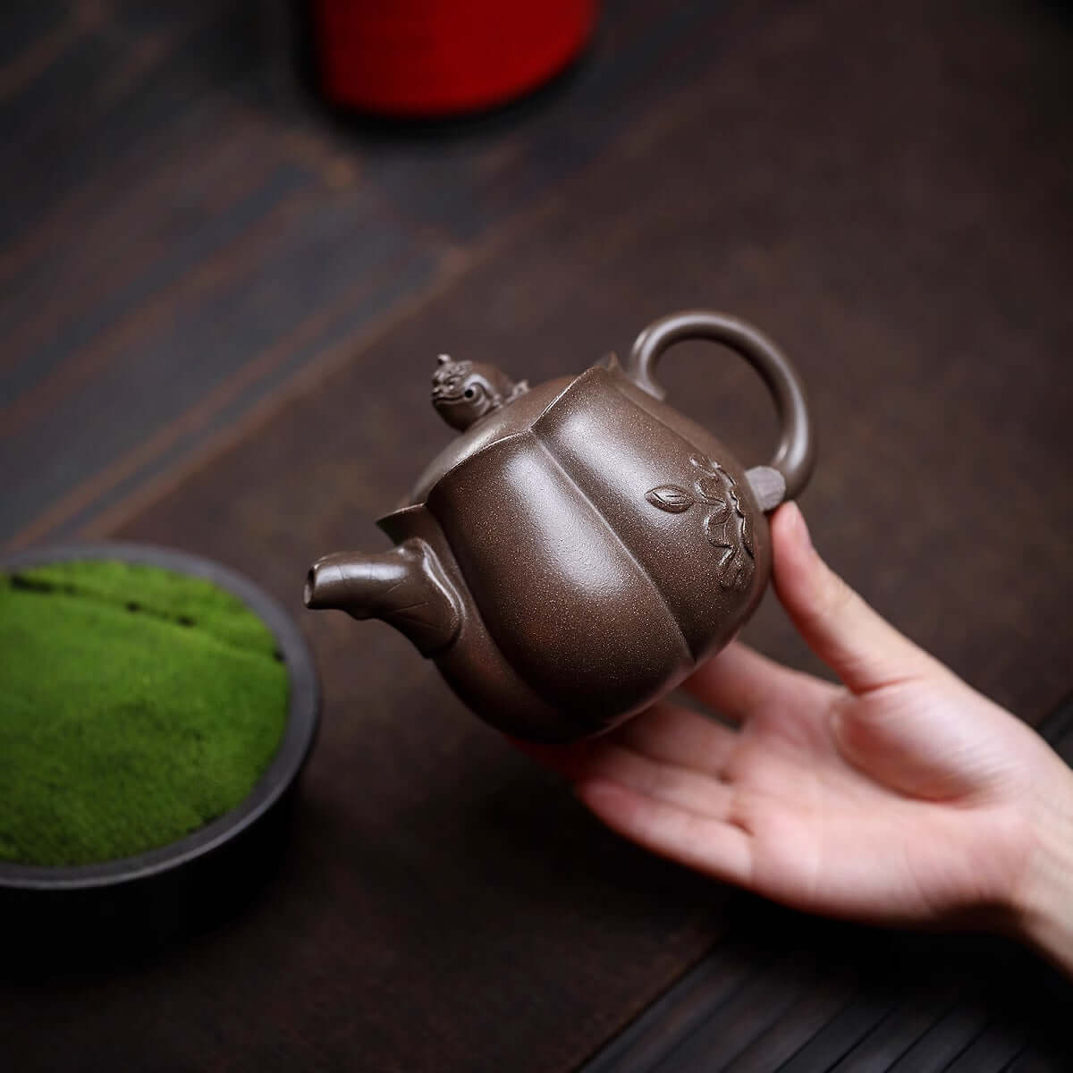 Handmade Yixing purple sand teapot in hand, showcasing fine craftsmanship and original purple sand material.