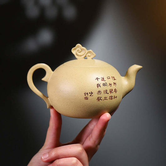 Handmade Yixing purple sand teapot with unique engraving and cloud motif, showcasing traditional craftsmanship.