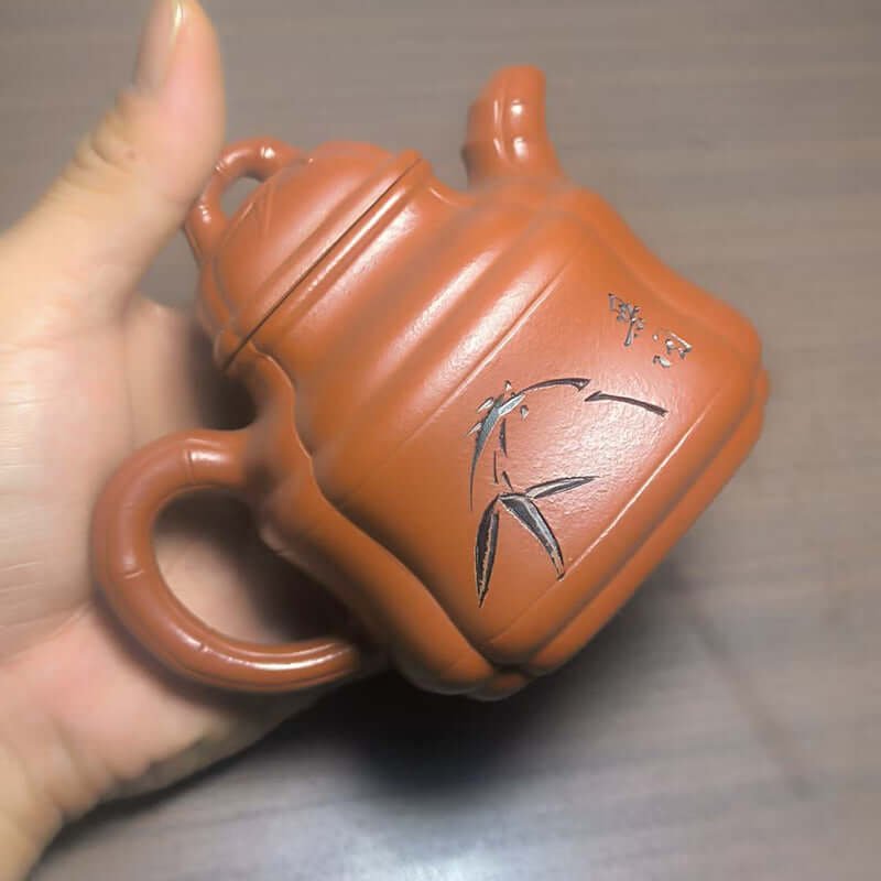 Handmade Yixing purple sand teapot featuring bamboo design, crafted by skilled artisans for home use.