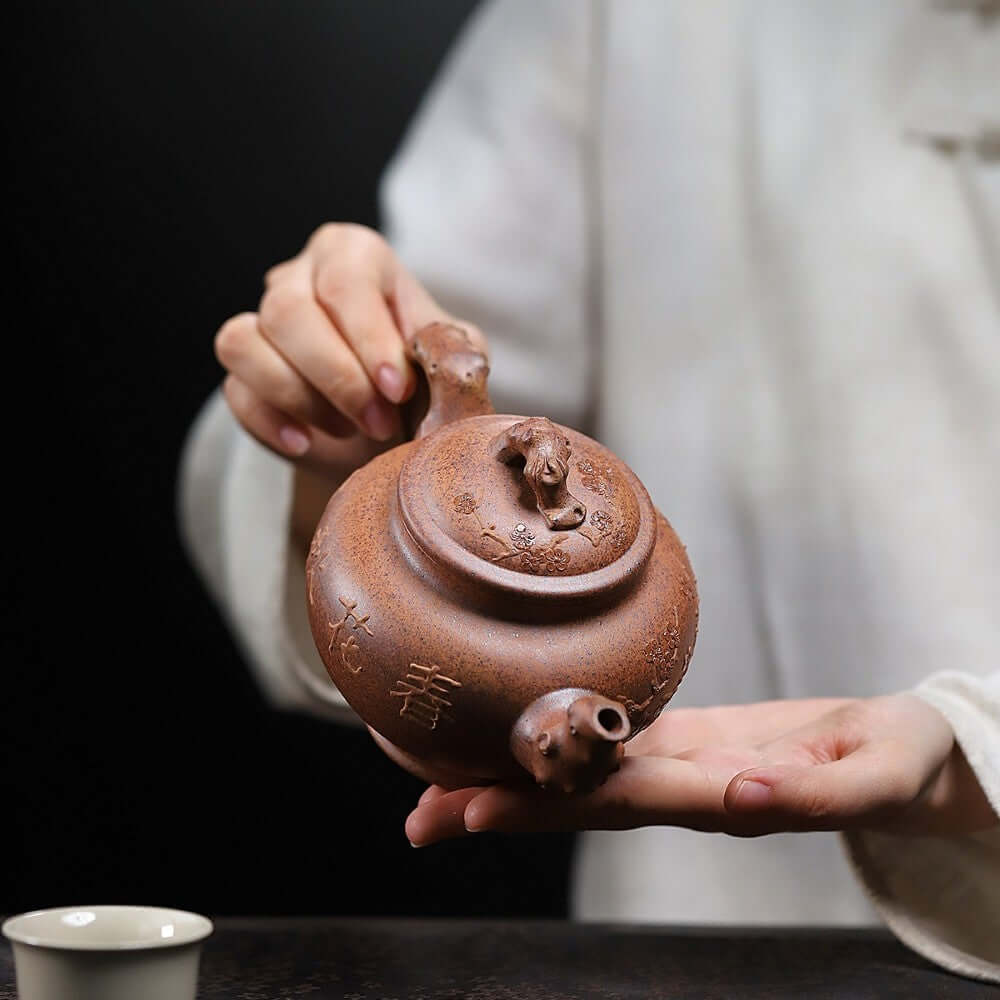 Handmade Yixing purple sand teapot, featuring intricate craftsmanship and a unique design, perfect for Kung Fu tea ceremonies.