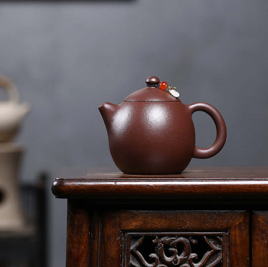 Handmade Yixing purple sand teapot on wooden table, showcasing original craftsmanship for Kung Fu tea sets.