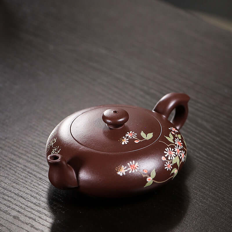 Handmade Yixing purple sand teapot with floral design, showcasing traditional craftsmanship and elegance.
