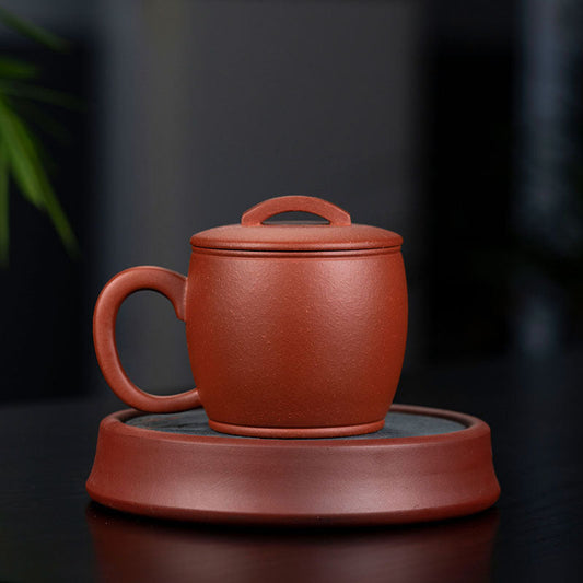 Handmade Yixing purple sand tea cup with lid on a saucer, showcasing authentic craftsmanship.