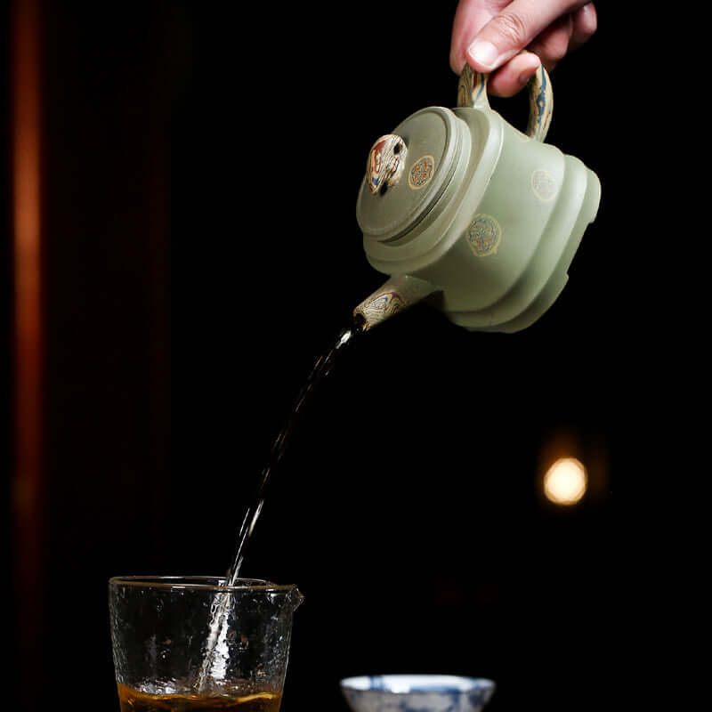 Handmade Yixing purple sand teapot pouring tea into a glass, showcasing elegant craftsmanship and traditional tea culture.