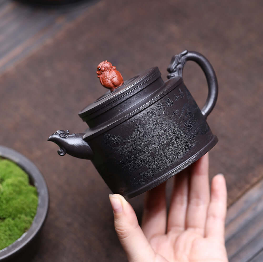Handmade Yixing purple sand teapot with intricate engraving and ornate lid, perfect for kung fu tea ceremonies.