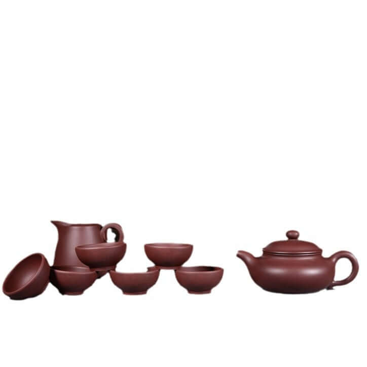 Handmade Yixing purple sand teapot set including a teapot, six cups, and a pitcher in a rustic design.