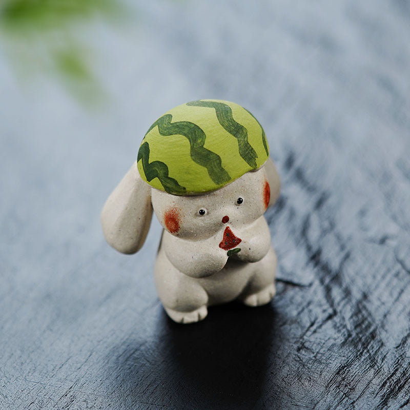 Handmade purple clay rabbit figurine with a green striped hat, perfect for tea decor or as a cute desk ornament.