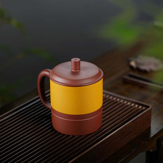 Handmade Yixing purple sand tea cup with cover, featuring a yellow and brown design, ideal for soaking tea.
