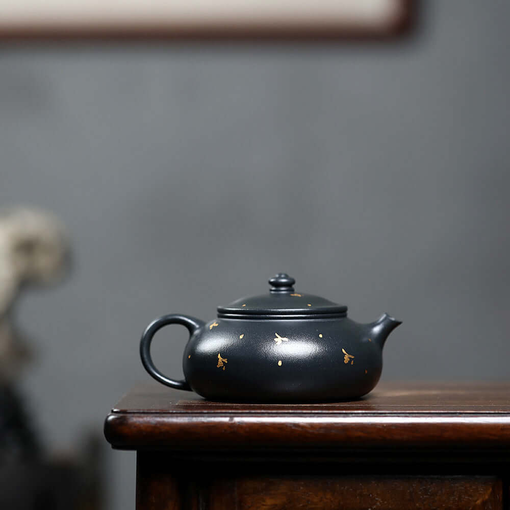 Handmade Yixing purple sand teapot with golden accents, perfect for home kung fu tea ceremonies.