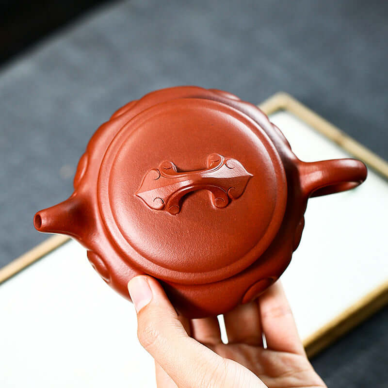 Handmade Yixing purple sand teapot with elegant design and smooth curves, showcasing traditional craftsmanship.