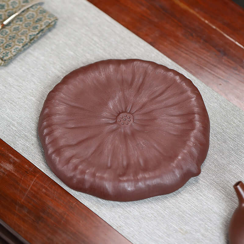 Handmade Yixing purple sand lotus pot pad, showcasing intricate design and unique texture for tea accessories.