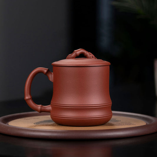 Handmade Yixing purple sand cup with bamboo cover, perfect for tea enthusiasts and authentic craftsmanship.