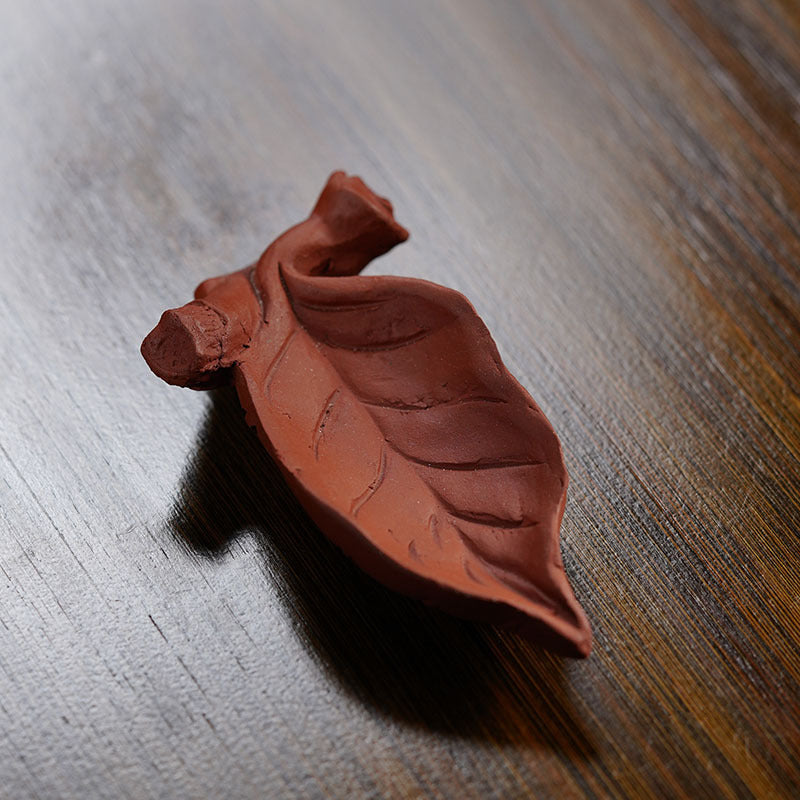 Handmade Yixing purple sand tea pet shaped like a leaf, ideal for tea ceremonies and decor.