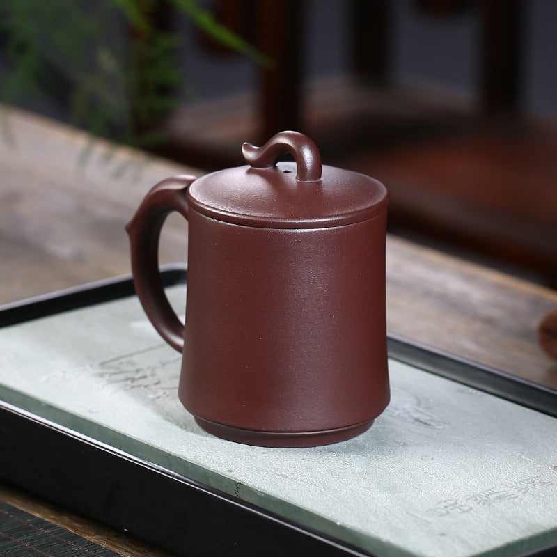 Handmade Yixing purple sand cup with elegant design and creative handle, perfect for tea lovers and collectors.
