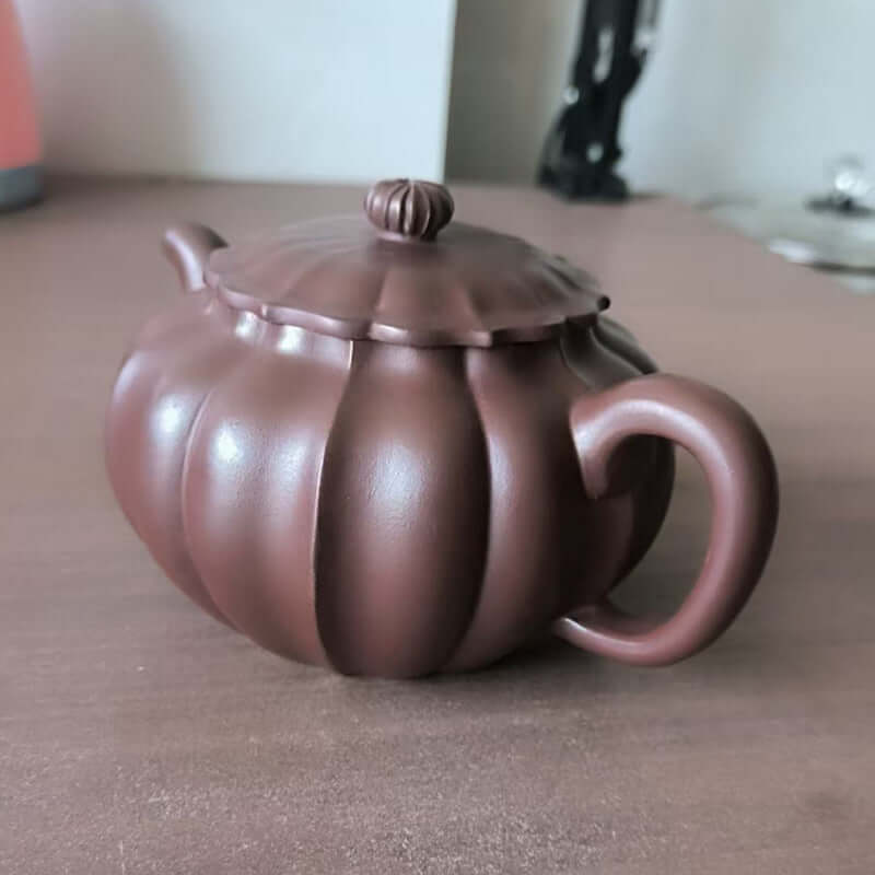 Handmade Yixing purple sand teapot with a pumpkin design, crafted from original purple sand.