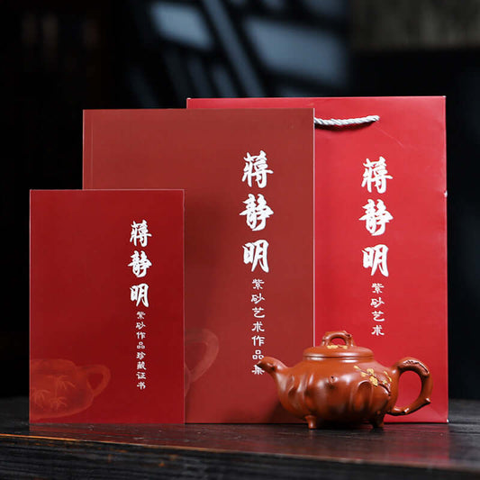 Handmade Yixing purple sand teapot with red packaging, featuring the artist's name and logo, showcasing fine craftsmanship.