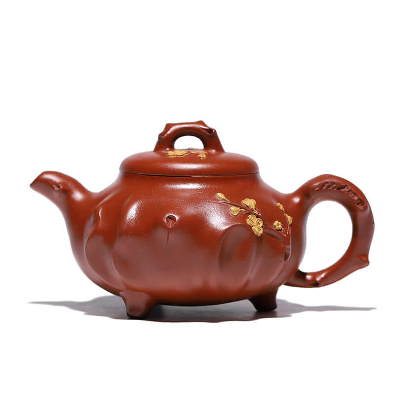 Handmade Yixing purple sand teapot with floral design, featuring a classic three-legged style and elegant craftsmanship.
