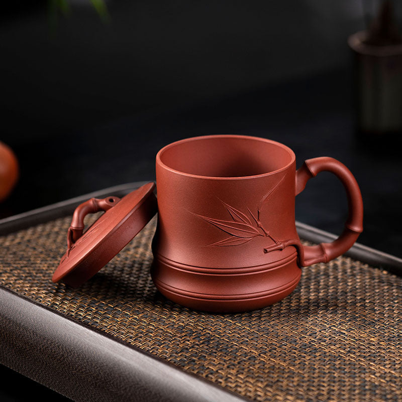 Handmade Yixing purple sand cup with bamboo cover, perfect for tea set enthusiasts and collectors.