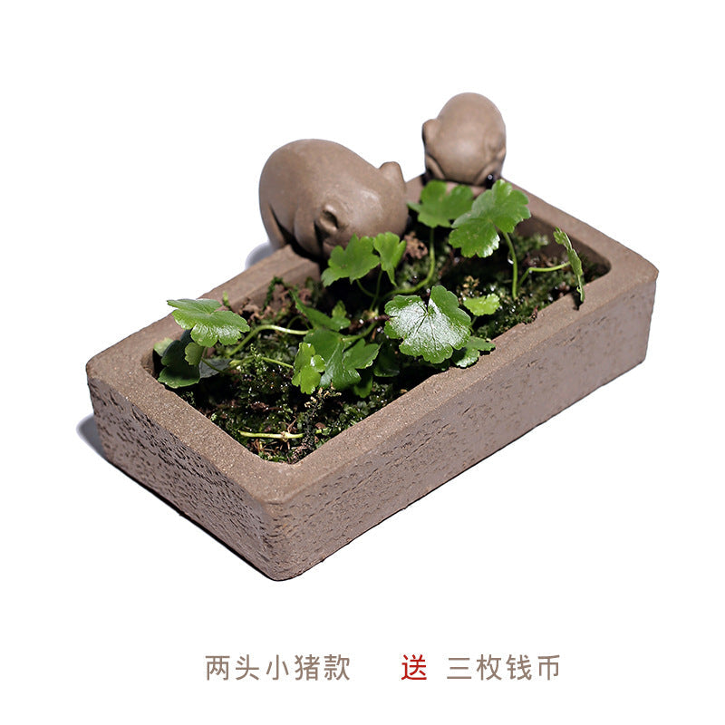 Handmade Yixing purple sand piglet tea pet with small plants in a clay pot, perfect for tea ceremony decoration.