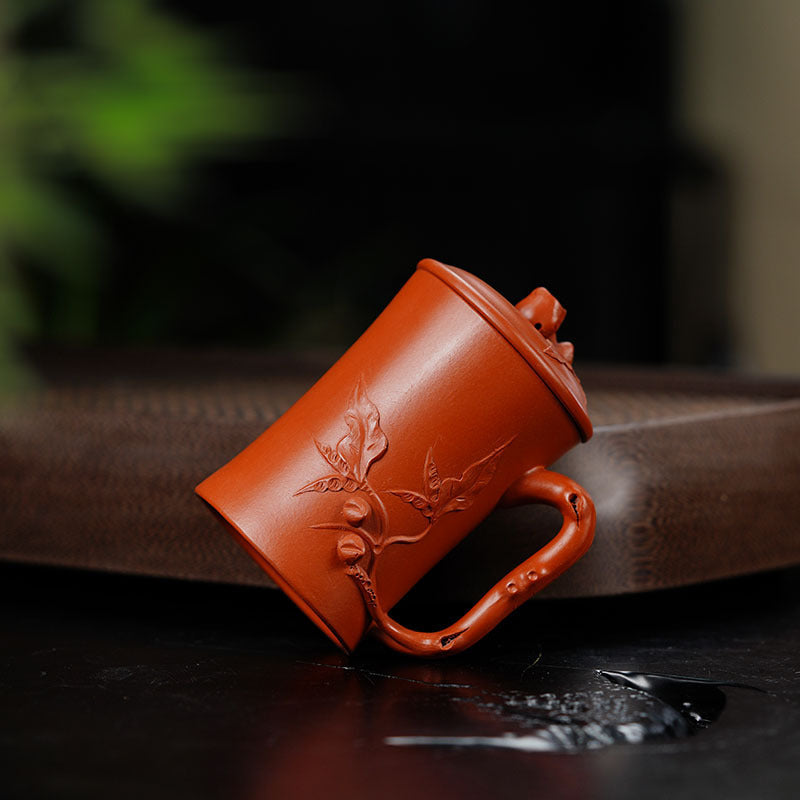 Handmade Yixing purple sand cup with floral design, perfect for tea enthusiasts and collectors.