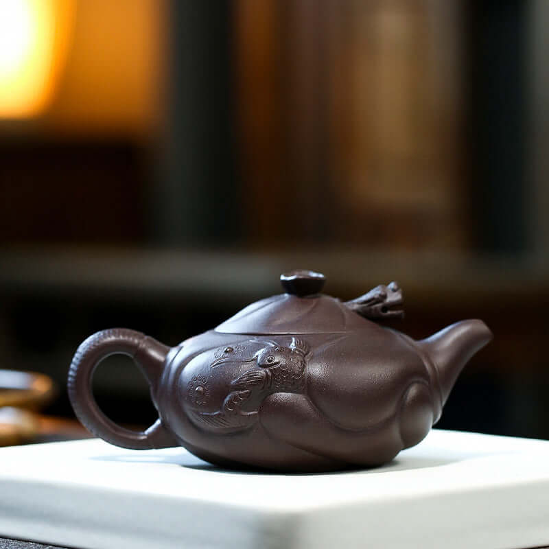 Handmade Yixing purple sand teapot featuring intricate fish dragon design, showcasing artistry and elegance for kung fu tea.