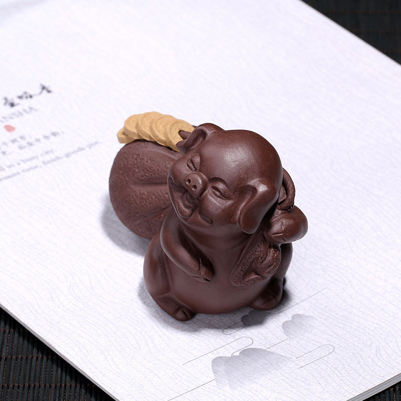 Handmade Yixing purple sand pig figurine for tea tray decoration with fortune symbol.