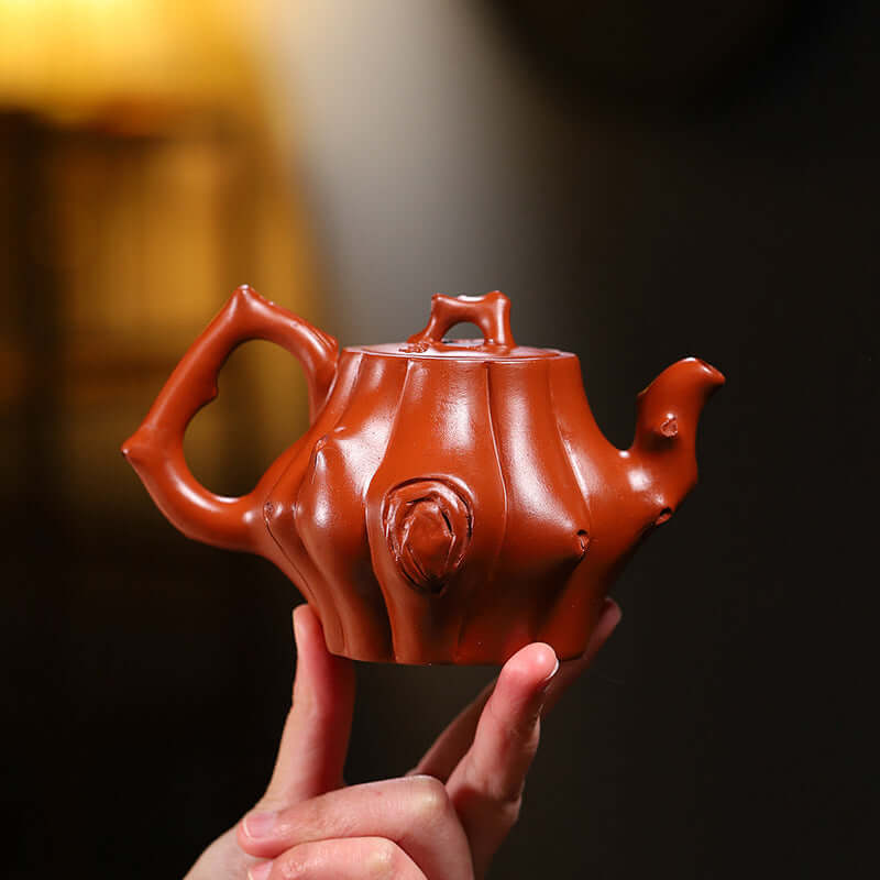 Handmade Yixing purple sand teapot with unique tree trunk design, showcasing craftsmanship and organic shape.
