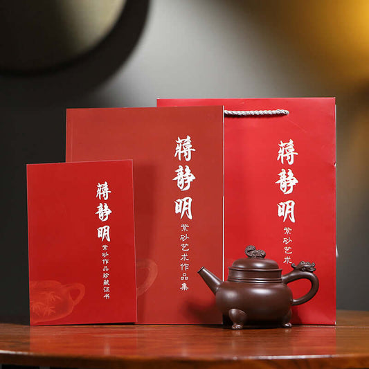 Handmade Yixing purple sand teapot displayed with red packaging and certificate, highlighting artisanal craftsmanship.