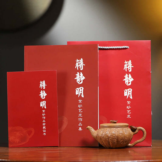 Handmade Yixing purple sand teapot displayed with packaging and certificates in a red gift box.
