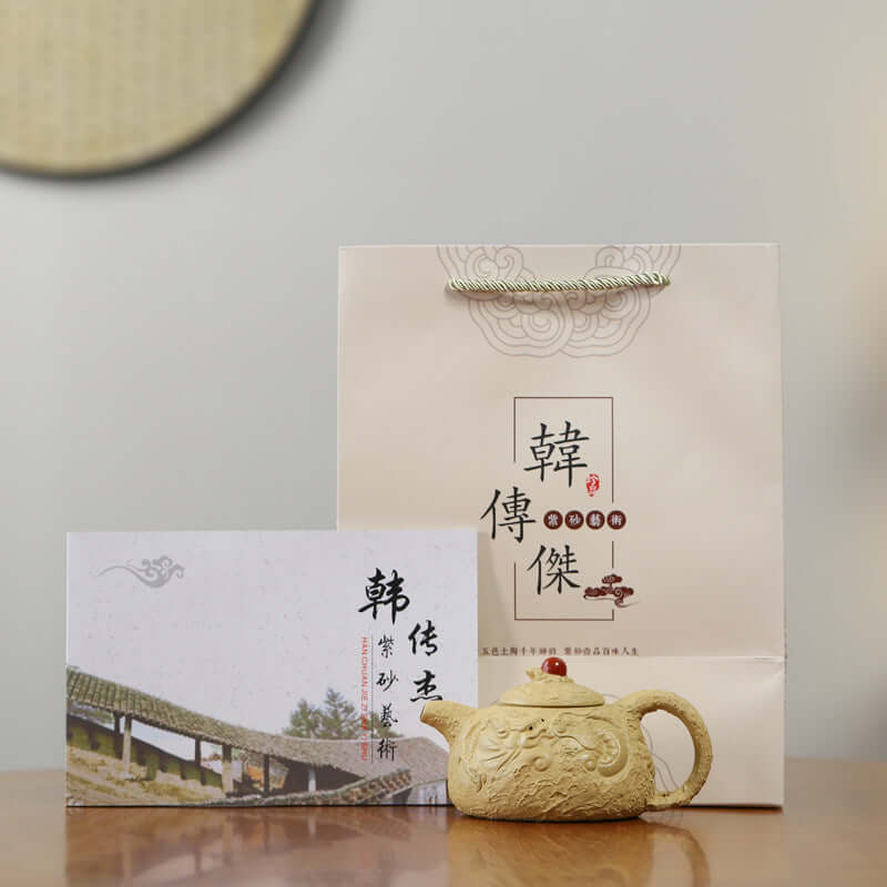 Handmade Yixing purple sand teapot with decorative packaging and certificate, ideal for tea enthusiasts.